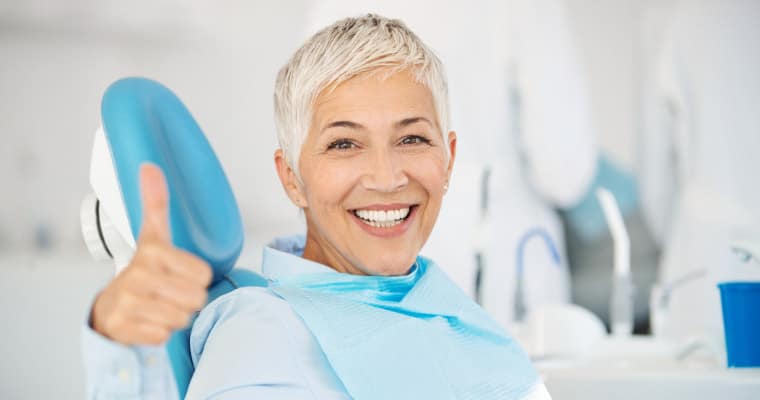 Dental implants patient with a thumbs up about being a good dental implants candidate